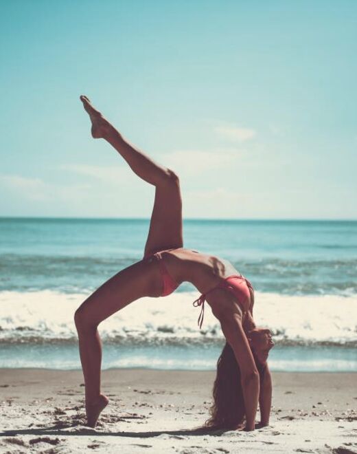 Práctica de yoga en la playa al amanecer