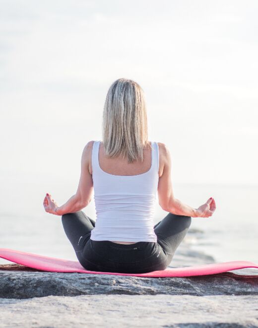 Meditación frente al mar sobre una colchoneta