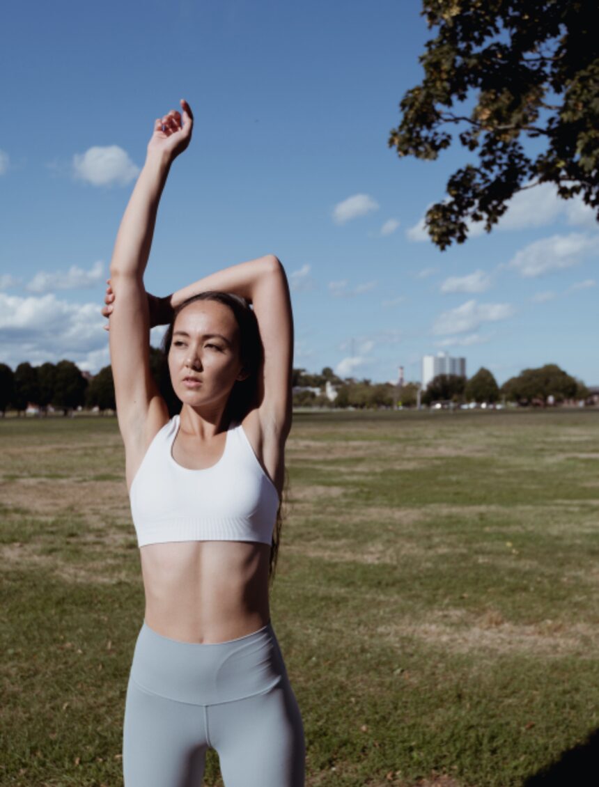 Mujer estirando al aire libre antes de entrenar